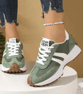 Green panelled women's sneakers with white laces and striped sides