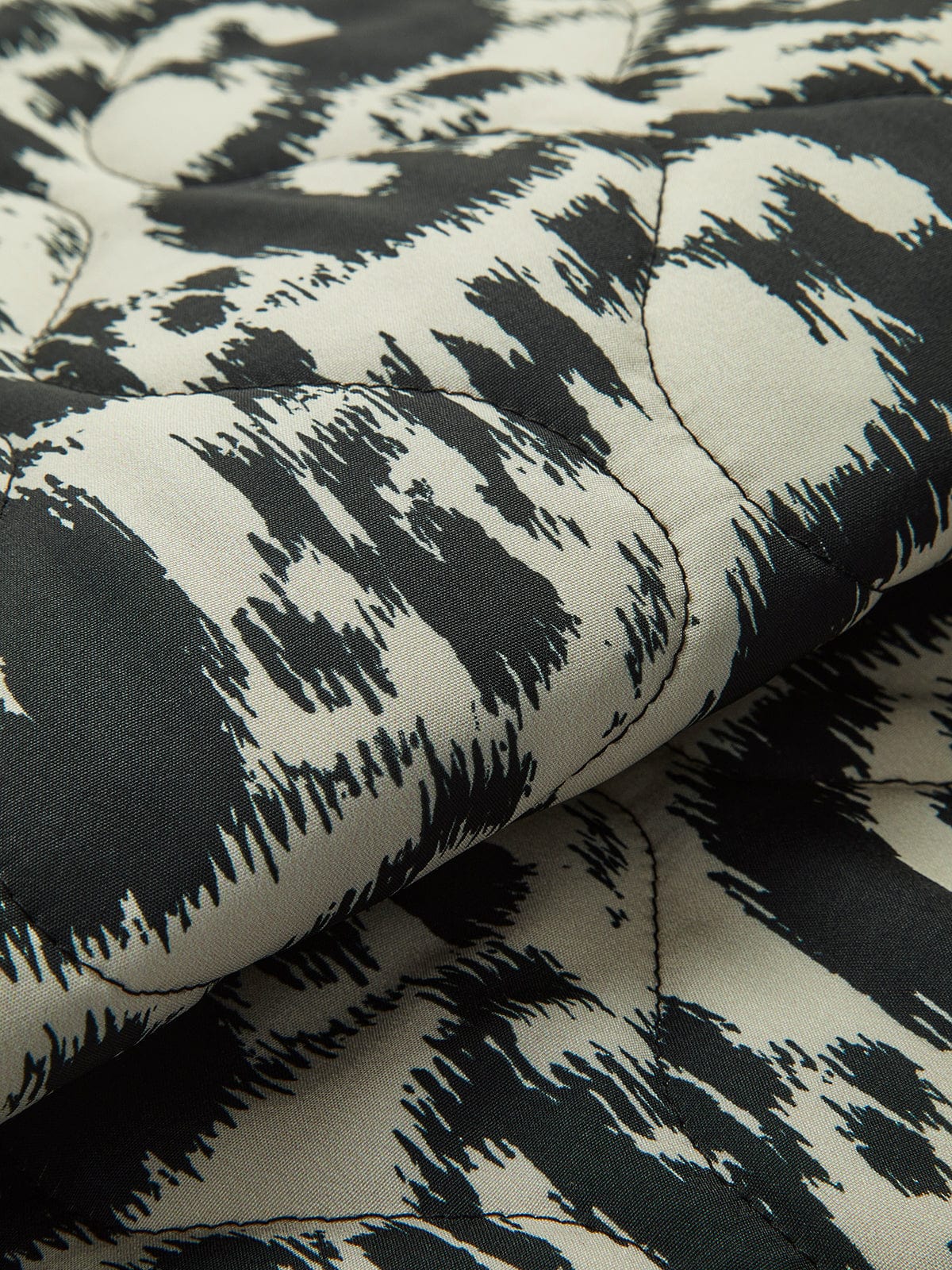 Women's black and white abstract animal print quilted collarless jacket