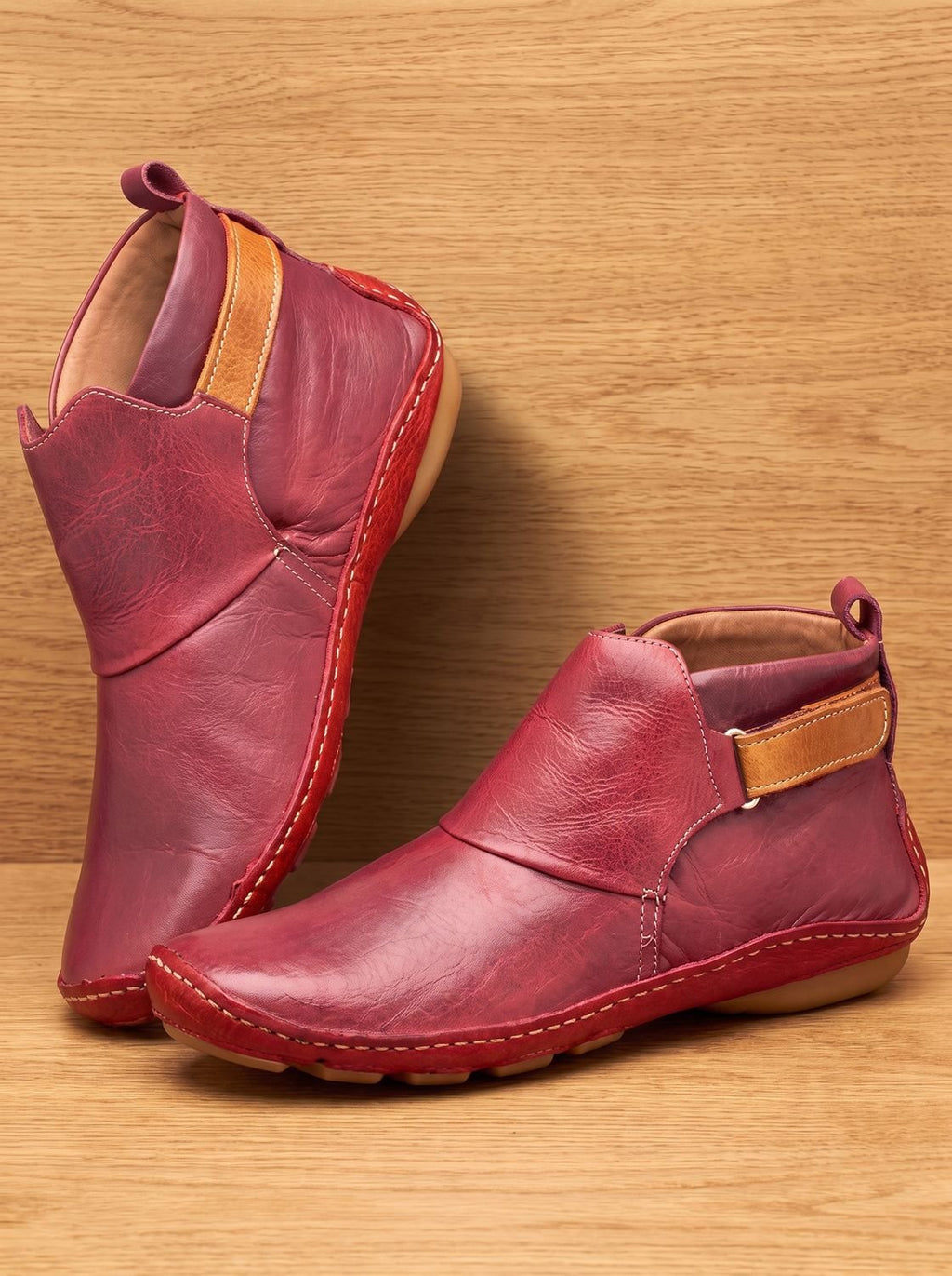Women's slip-on ankle boots with rounded toes, stitched panels and flat heels