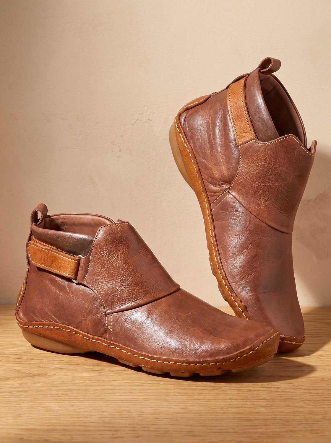 Women's slip-on ankle boots with rounded toes, stitched panels and flat heels