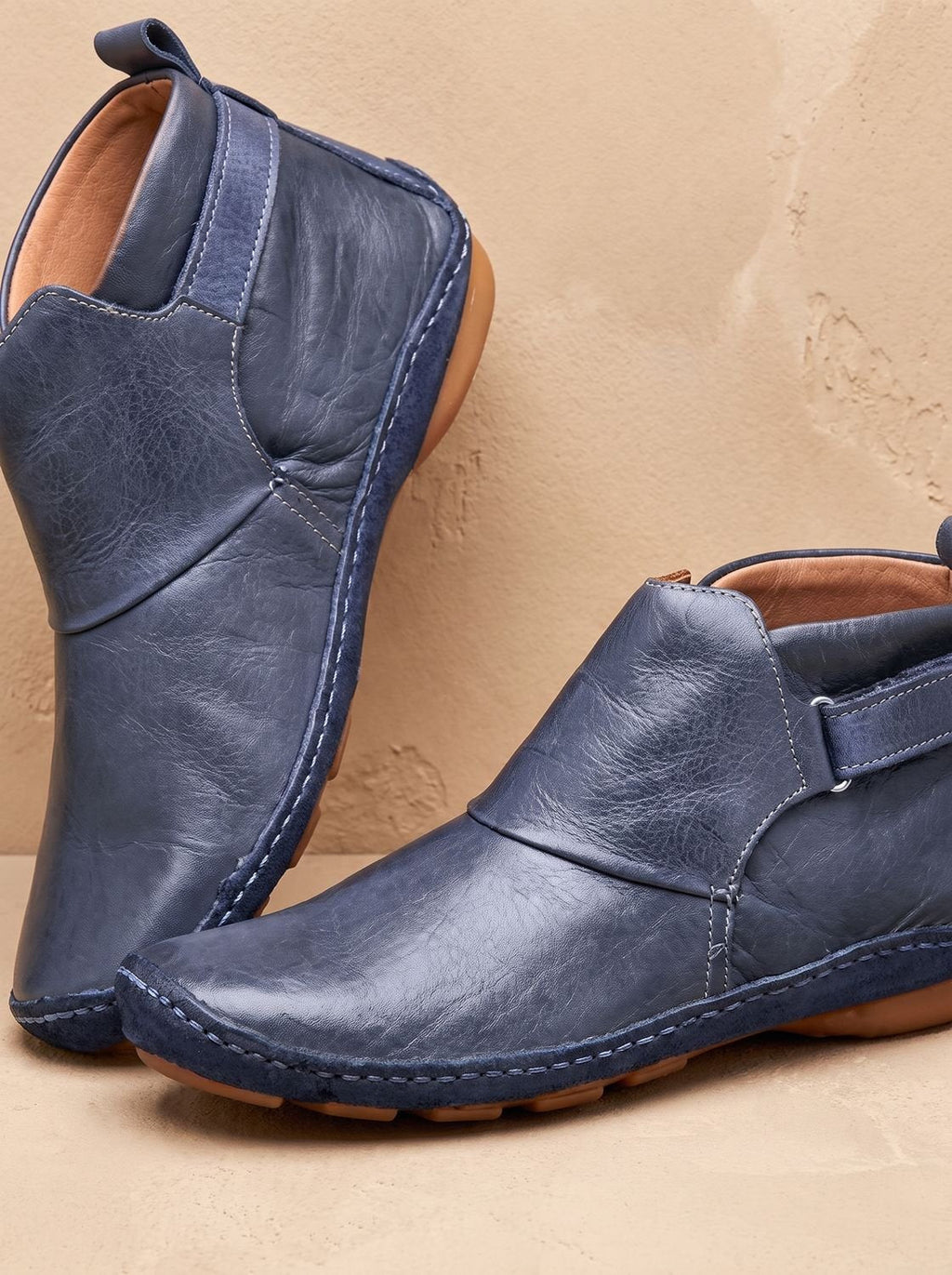 Women's slip-on ankle boots with rounded toes, stitched panels and flat heels